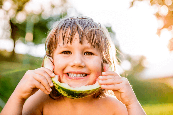Boy smiling with watermelon - Know Your Smile Will Last